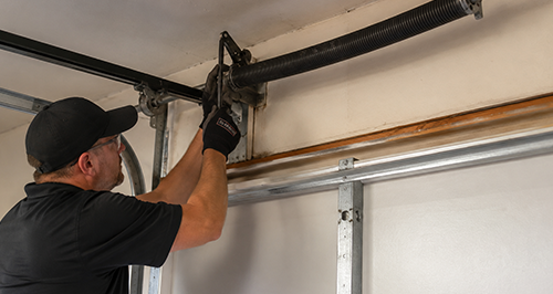 Garage Door Spring Installation Technician Repairing New Torsion Spring